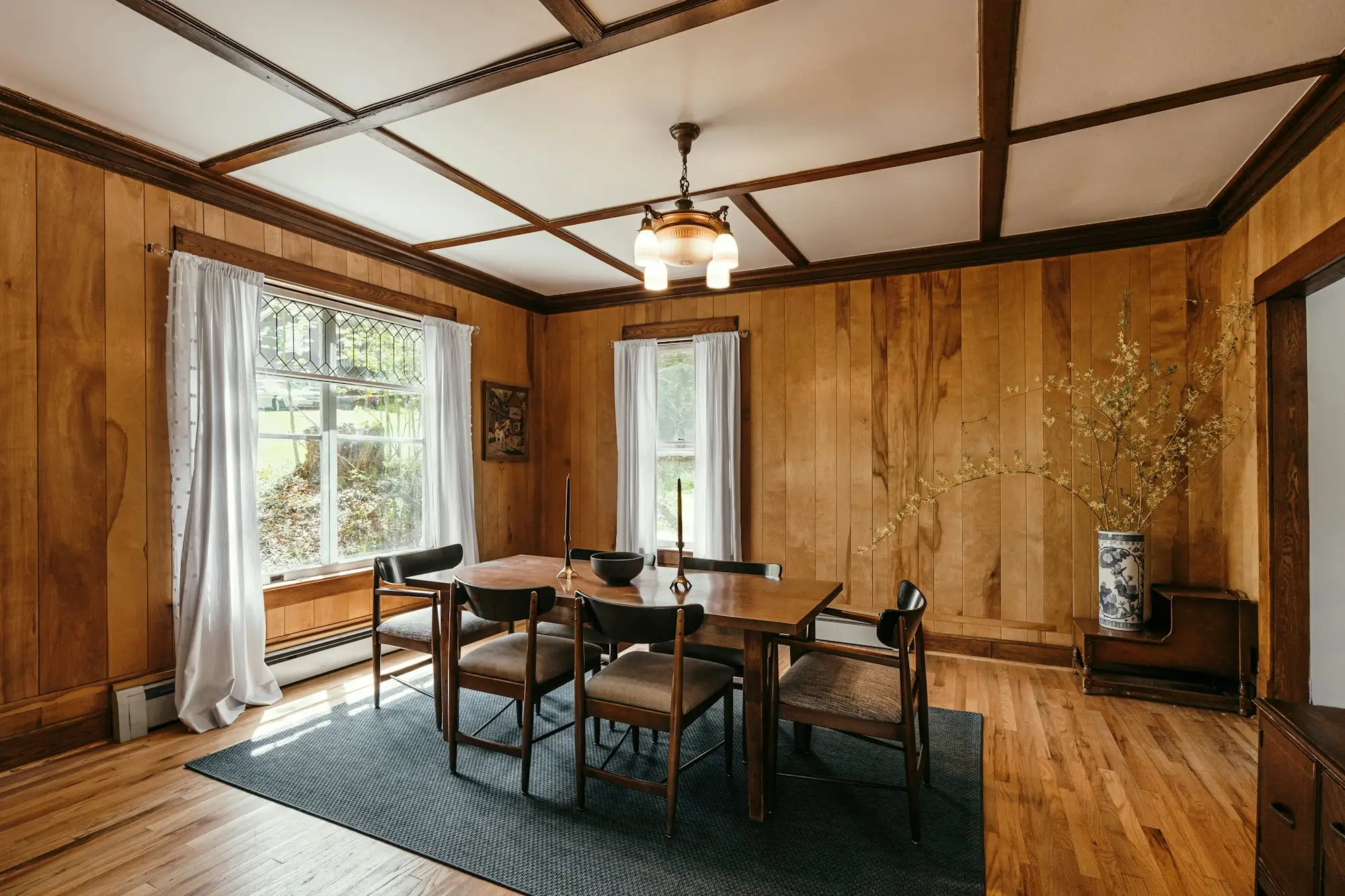 Rebuilt dining room with wood paneling and a long table