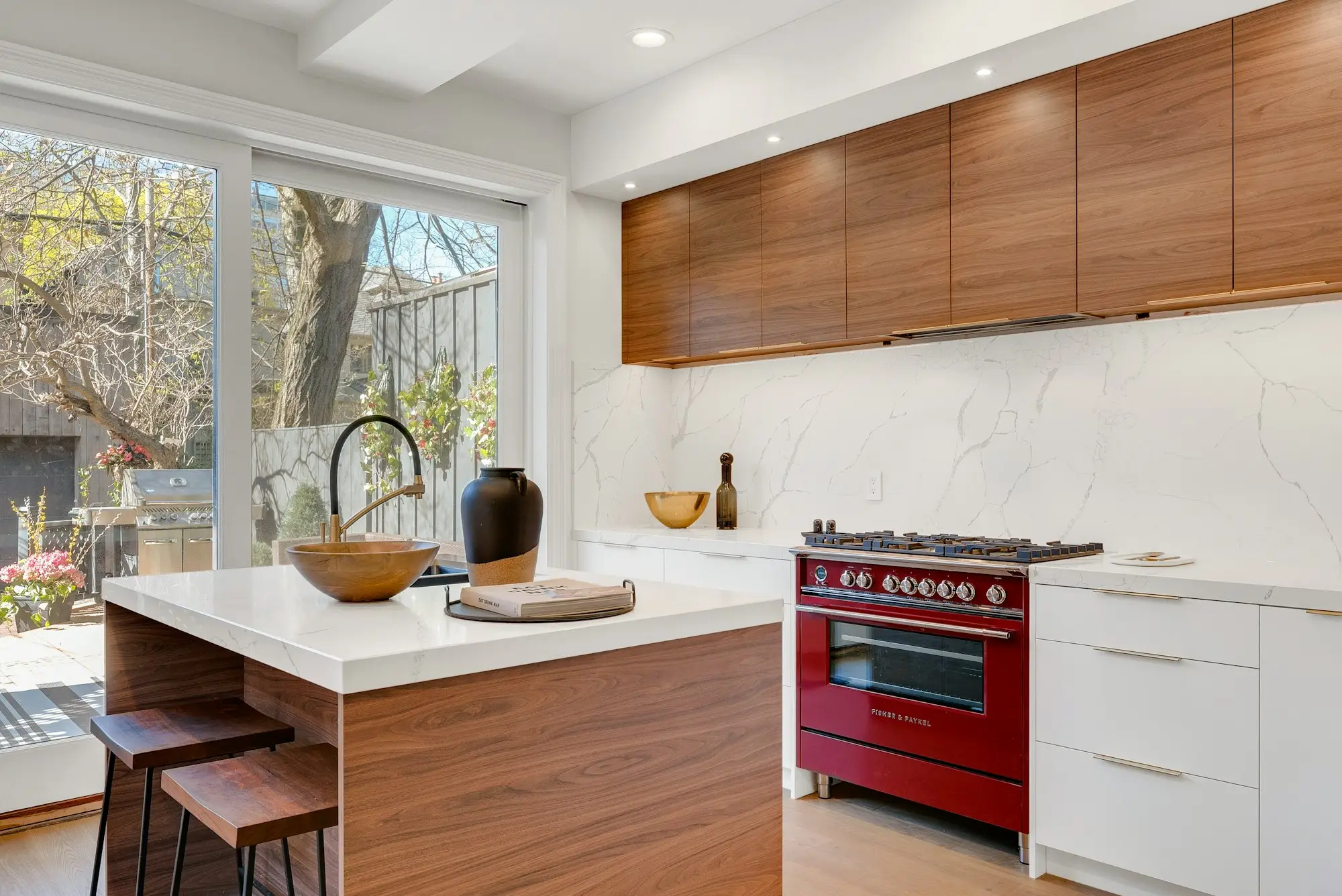 Kitchen island beside a stainless range and white cabinets