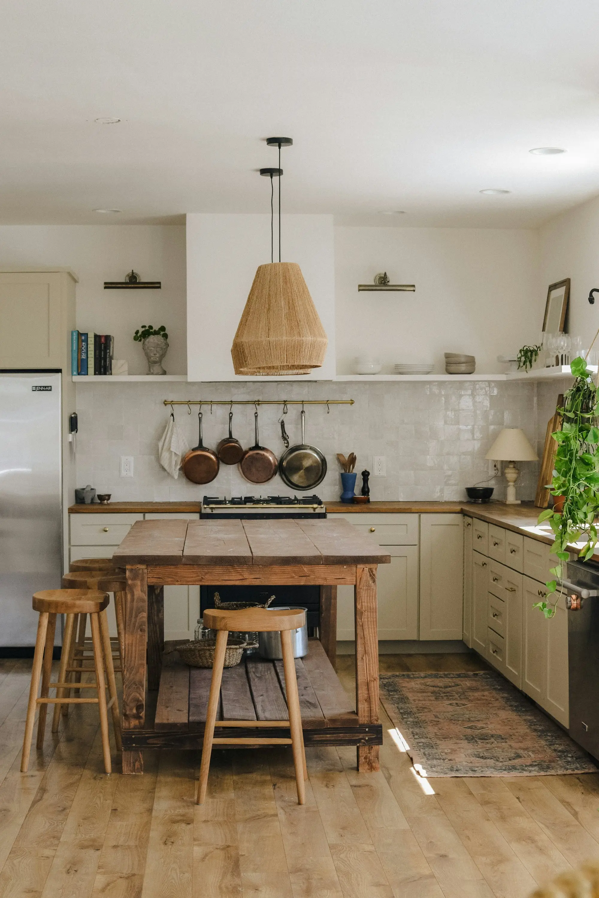 Wood kitchen with a large island, stools, and open shelves