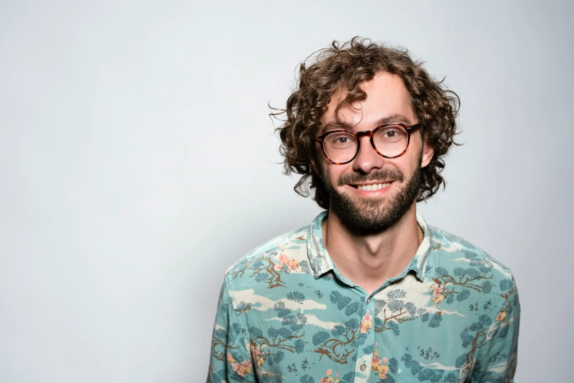 Portrait of Jonah Peck, a man with glasses and a beard in a gray sweater