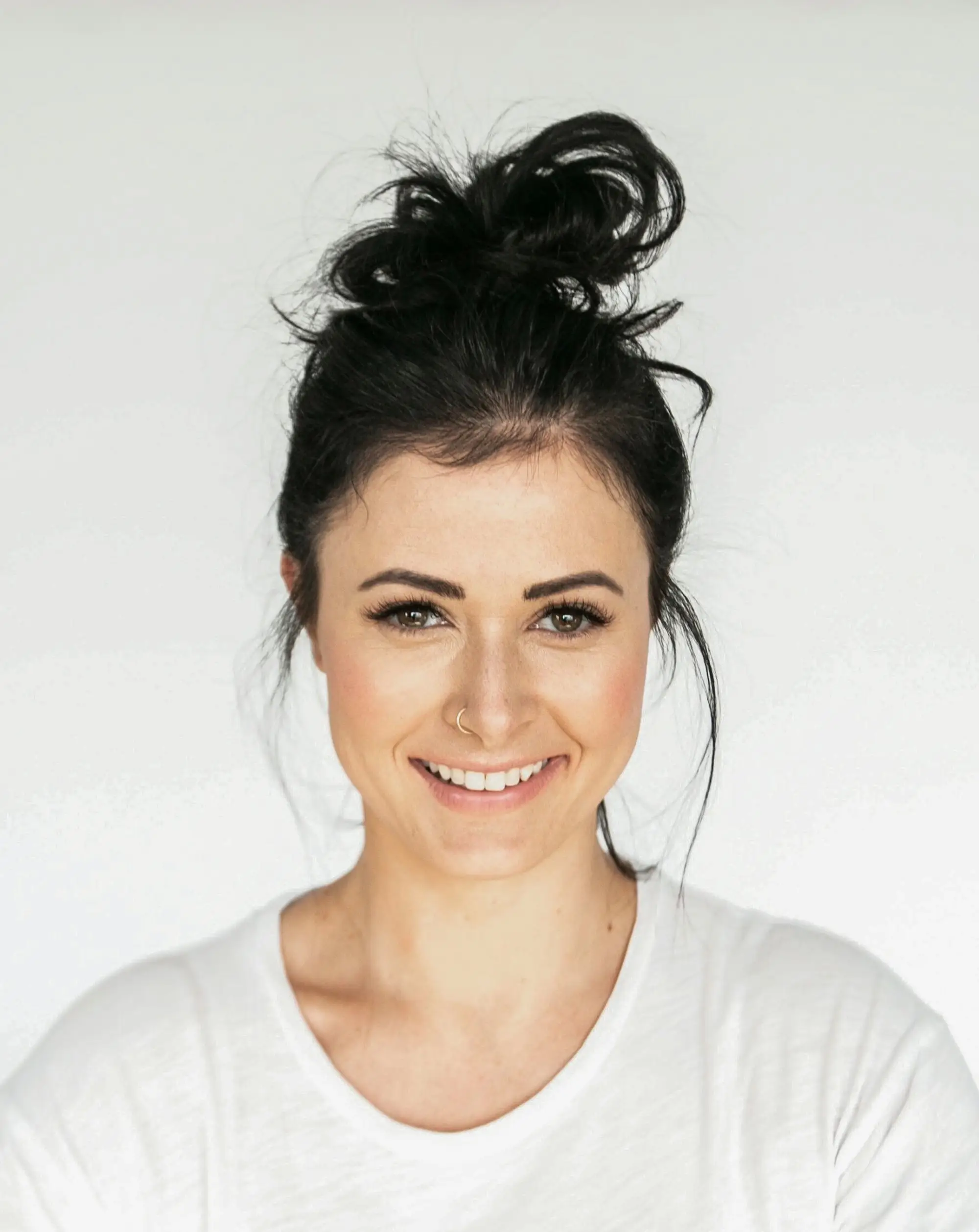 Portrait of Mara Ellison, a woman with dark hair pulled back, wearing a white shirt